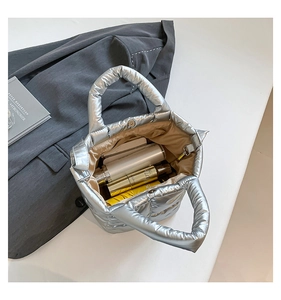 Detail view of the silver metallic quilted bag interior with magnetic closure and cosmetics