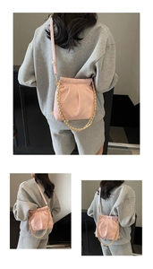 Detail view of pink quilted drawstring bucket bag with gold chain and leather strap