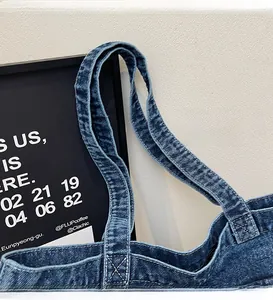 Detail of smooth denim shoulder straps on a casual large tote bag with neat stitching