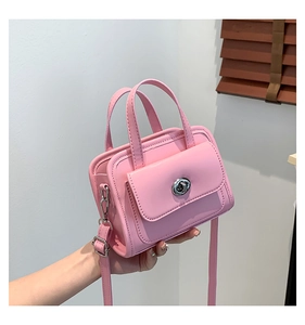 Detail of light pink mini handbag with silver twist lock and smooth leather texture
