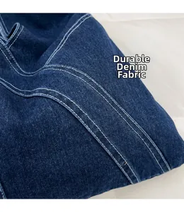 Close-up detail of sturdy dark blue denim fabric with reinforced double white stitching