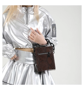 Detail of a brown snakeskin pattern crossbody bag with black chunky chain strap