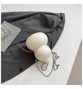 Detailed view of gourd-shaped white creative bag with metallic chain and woven cord