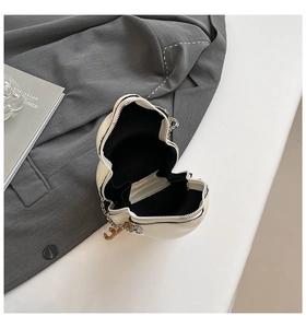 Detailed view of the gourd-shaped crossbody bag featuring silver chains and gold charms