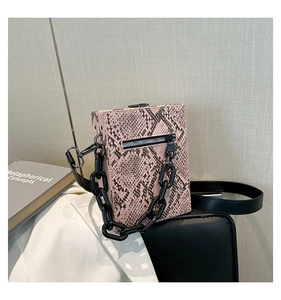 Close-up of pink snakeskin pattern small square bag with chain and leather strap