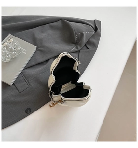 Top view of cream white gourd-shaped crossbody bag with gold chain and black lining