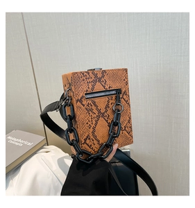 Detail of trendy brown python skin crossbody bag with chunky black chain and silver zipper