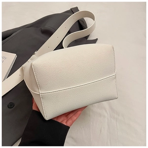 Detail einer weißen Tote Bag mit Litschi-Textur und breitem, verstellbarem Schultergurt