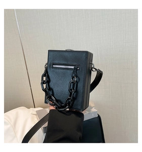 Detail of black crossgrain leather crossbody bag with silver zipper and plastic chain