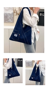 Detail of deep blue denim tote bag featuring rainbow patch and unique triangular design