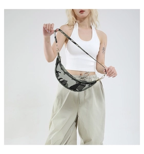 Detailed view of camo crescent bag with golden hardware on model in studio