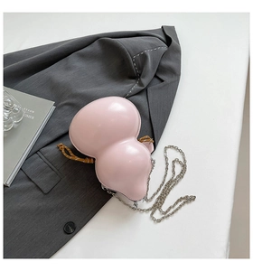 Detailed macro view of pink gourd-shaped crossbody bag with silver chain and woven knot