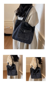 Detail of grey denim tote bag featuring a large front pocket and washed vintage texture