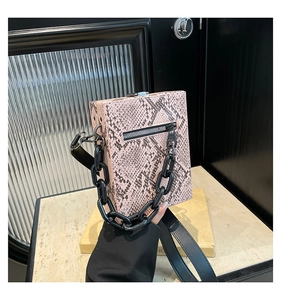 Detail of pink snakeskin pattern small crossbody bag with black chain and metal buckle