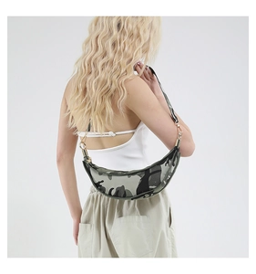 Detail view of crescent camo crossbody bag worn by a model with gold hardware accents
