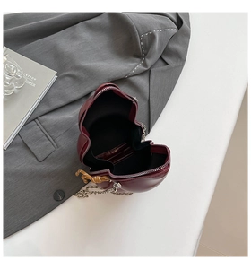 Macro detail of wine red gourd-shaped crossbody bag with silver chain and internal pocket