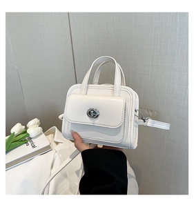 Detailed view of white mini handbag with silver twist lock and smooth leather texture