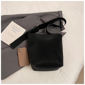 Flachbild einer schwarzen minimalistischen Beuteltasche mit breitem Schultergurt