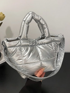 Silver metallic quilted puffer tote bag with padded handles and square stitching texture
