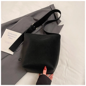 Details der schwarzen Beuteltasche mit breitem Schultergurt und silberner Metallschnalle