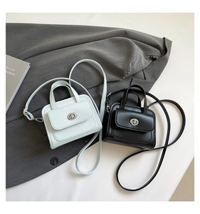 Detail of minimalist leather mini square bags in black and beige with silver twist locks