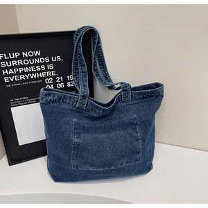 Detailed close-up showing the heavy-duty washed denim fabric texture of the tote bag