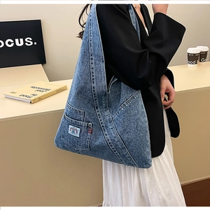 Detailed shot of washed denim tote bag with rainbow tag on small outer pocket