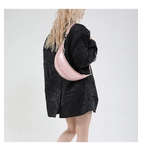 Pink minimalist crescent bag with fine leather texture shown on model side profile