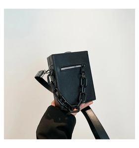 Detail of black faux lizard embossed box bag with chunky matte chain and silver zipper