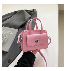 Detailed close-up of a pink briefcase handbag featuring a silver twist lock on the front pocket