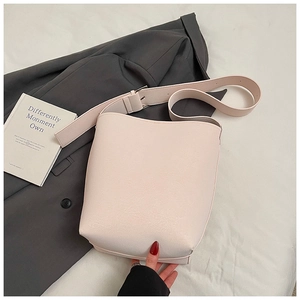 Detail der minimalistischen Beuteltasche aus beigem Kunstleder mit breitem Schultergurt