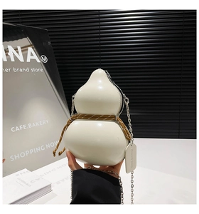 Detailed view of cream gourd-shaped bag with chain strap and decorative waist rope