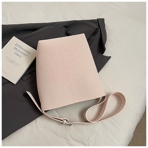 Detailansicht der rosa Beuteltasche mit verstellbarem Gurt auf grauem Blazer