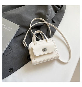 Detail of a minimalist off-white handbag with silver metal twist lock and round handle