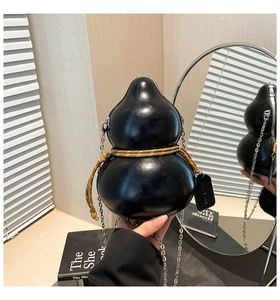 Detail of creative gourd-shaped crossbody bag in glossy black finish with silver chain strap