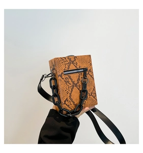 Detail shot of snakeskin print small square bag featuring a bold black chunky chain strap