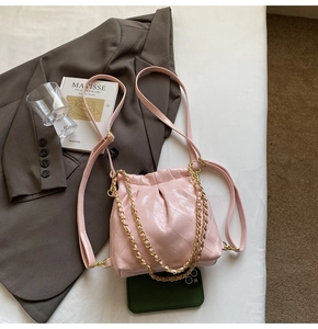 Close-up of pink quilted leather bag featuring a gold chain strap and elegant fold detail