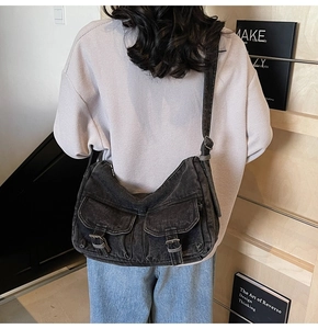 Detailed view of vintage washed denim motorcycle bag with silver buckles and wide strap