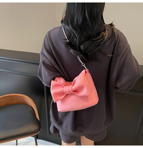 Detailed back view of a pink bow shoulder bag with elegant silver metal chain strap