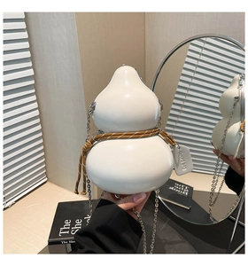 Close-up of a white gourd-shaped shoulder bag with decorative ropes and a silver chain