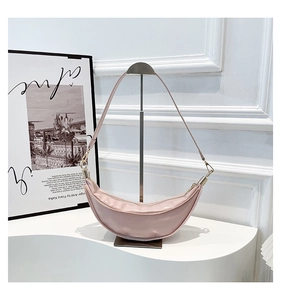Detail view of pink patent leather crescent bag showing glossy texture and gold hardware