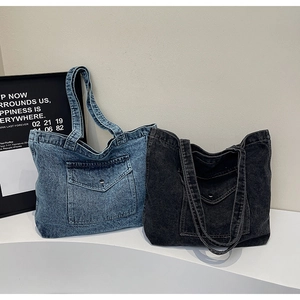 Detail of vintage denim tote bags with large snap-button front pockets and rugged texture