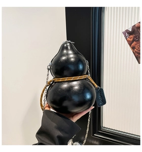 Detail of creative black gourd shaped bag with woven brown cord and silver chain strap