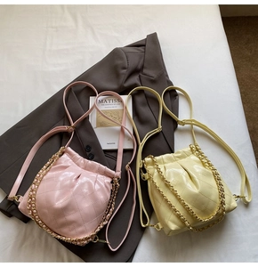 Detailed close-up of pink and yellow quilted mini bucket bags with gold chain straps