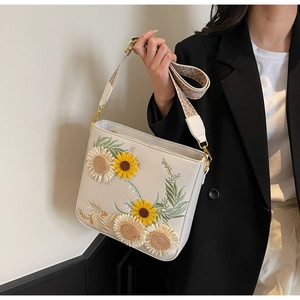 Detail of white PU shoulder bag with floral sunflower embroidery and jacquard strap