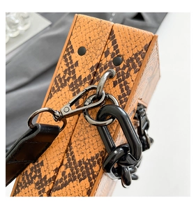 Detail of orange python print box bag with black resin chain and metal hardware