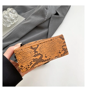 Detailed view of the brown snake skin texture and metal zipper on the square handbag