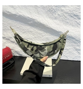 Detailed close-up of camouflage crescent bag with gold metal hooks and durable zipper