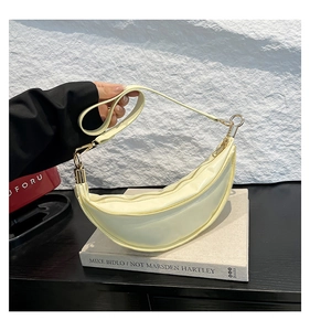 Detailed close-up of light yellow crescent moon bag with glossy PU leather and gold zipper