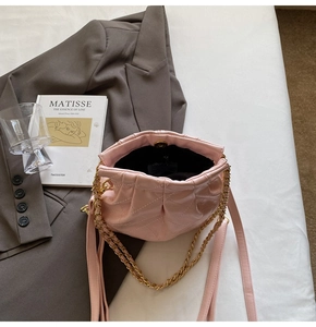 Detail of pink quilted chain bag with glossy finish and secure magnetic clasp closure